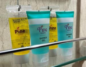 a group of four bottles of sunscreen on a shelf at Latitudo Suites Uganda in Kajansi