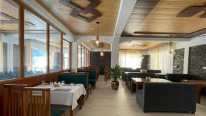 a dining room with tables and chairs and windows at Julley Jispa in Jispa