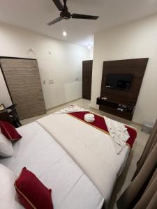 a bedroom with a large bed with a ceiling fan at Hotel Fortune 36 in Bangalore +7 photos