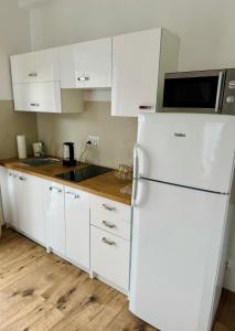 a kitchen with white cabinets and a white refrigerator at Willa u Marioli in Ściegny