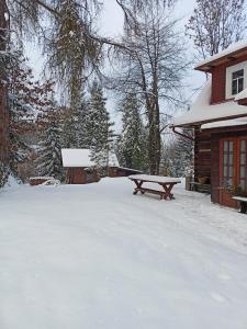 a picnic table in the snow next to a cabin at Willa Witówka in Olszówka