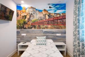 a room with a wall mural of a bridge at New Hostal Cabañas in Carboneras de Guadazaón