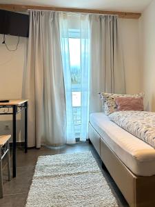 a bedroom with a bed and a large window at Three bedroom apartment in Dingolfing +7 photos