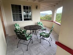 a patio with a table and chairs on a balcony at Amazing Antigua Getway in Bolans