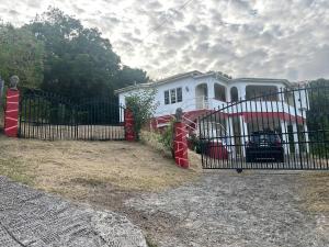 a white house with a fence in front of it at Amazing Antigua Getway in Bolans