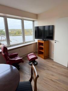 a living room with a television and two chairs at Palaceblick in Schleswig