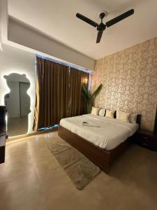 a bedroom with a bed with a ceiling fan at Fifth Heaven Studio at Spectrum Mall in Noida