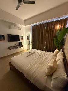 a bedroom with a large bed with a large window at Fifth Heaven Studio at Spectrum Mall in Noida