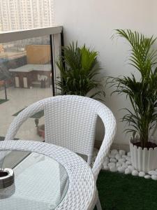 a white wicker chair in a room with plants at Fifth Heaven Studio at Spectrum Mall in Noida