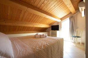 ein Schlafzimmer mit einem großen Bett und einer Holzdecke in der Unterkunft Hotel Lara in Riccione + 41 Fotos