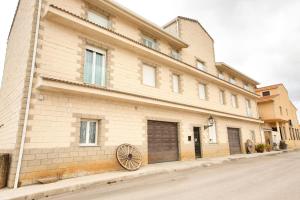 a building with a wheel on the side of it at New Hostal Cabañas in Carboneras de Guadazaón