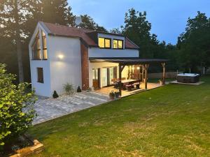 a house with a patio and a grill in a yard at Villa BELEVITA odmor u prirodi sa grijanim bazenom in Čepelovac