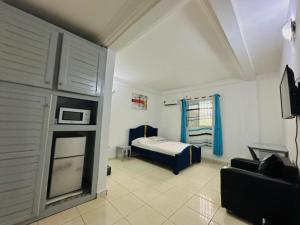 a bedroom with a bed and a couch in a room at CAMERHOME Lycée Cité des palmiers in Douala