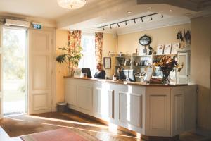 a woman sitting at a counter in a coffee shop at Färna Herrgård & Spa in Färna