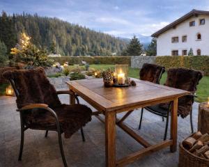 a wooden table with chairs and candles on a patio at Laax Cozy Apartment - Ski Bus - Fireplace in Laax +23 photos