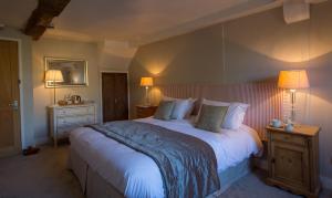 Un dormitorio con una cama grande y dos lámparas. en The Angel at Burford, en Burford