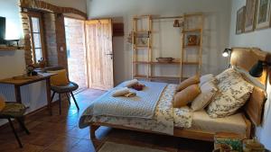 a bedroom with a bed with a wooden headboard at Penzion PROVANS - Pálava in Dolní Dunajovice