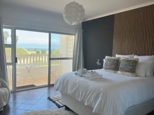 a bedroom with a large bed with a large window at Poseidon Beachfront Holiday Home in Swakopmund