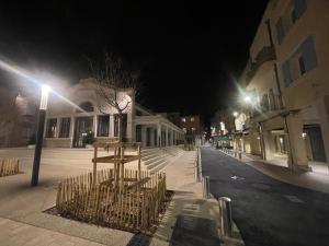 an empty city street at night with street lights at Appartement avec mini suite vue Cathédrale in Cavaillon