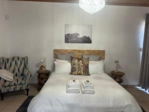 a bedroom with a large white bed with shoes on it at Poseidon Beachfront Holiday Home in Swakopmund