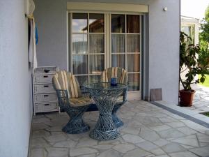 a glass table and two chairs on a patio at Seevilla Nina in Maria Wörth
