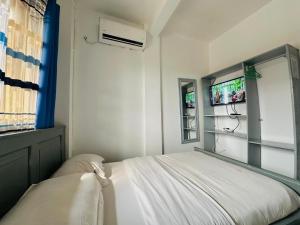 a small bedroom with a bed and a window at CAMERHOME Lycée Cité des palmiers in Douala