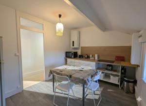 a kitchen with a table and chairs in a room at Studio spacieux avec bureau - Calme & Proche Lyon in Irigny