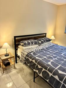 a bedroom with a bed with a blue and white comforter at Castell Cottages Central with Parking in Caerphilly