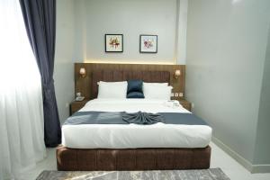 a bedroom with a large bed with a wooden headboard at Habor Hotel & Suites- Abuja in Abuja