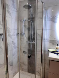 a shower with a glass door in a bathroom at Seevilla Nina in Maria Wörth