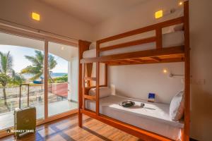 a bedroom with bunk beds with a view of the ocean at Monkey Tribe Alleppey in Alleppey