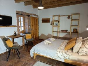 a bedroom with a bed and a desk and a table at Penzion PROVANS - Pálava in Dolní Dunajovice