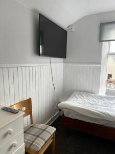 a bedroom with a bed and a tv on the wall at The Staging Post in Aberdeen