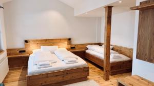 two twin beds in a room with wooden floors at Vogelbauer Apartments in Egling