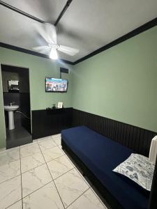 a bedroom with a bed and a ceiling fan at Pousada Amizade in Foz do Iguaçu