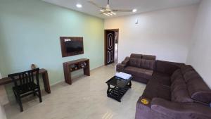 a living room with a couch and a tv at I Rose Guest House By Olive in Talaulim