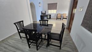 a dining room with a black table and chairs at I Rose Guest House By Olive in Talaulim +9 photos