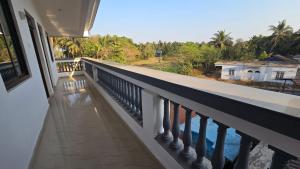 a balcony with a view of the water at I Rose Guest House By Olive in Talaulim