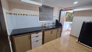 a kitchen with a sink and a counter top at I Rose Guest House By Olive in Talaulim