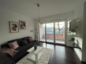 a living room with a black couch and a table at Faraway Homes Studio Bruck #11 in Bruck an der Mur
