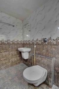 a bathroom with a toilet and a sink at Sai Arya Residency By The Avyaan in Mangalore