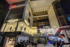 a large building with motorcycles parked in front of it at Sai Arya Residency By The Avyaan in Mangalore