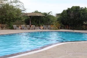 a swimming pool with a fountain in the middle at Mara Maisha Camp in Talek