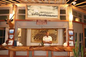 a man standing in front of a room with a table at Mara Maisha Camp in Talek