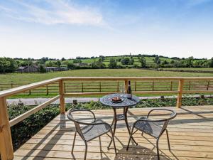 a table and chairs on a deck with a bottle of wine at 1 Bed in Matlock oc-96256 in Crich