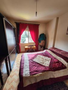 a bedroom with a large bed and a window at Cozy Stay in Baabda