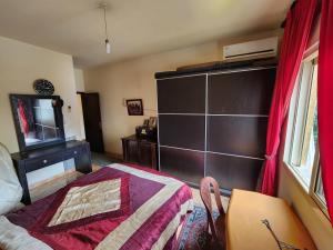 a bedroom with a bed and a dresser and a television at Cozy Stay in Baabda