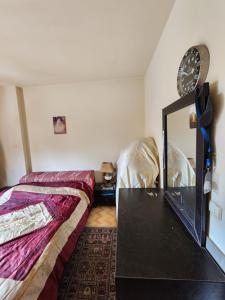 a bedroom with a bed and a dresser and a mirror at Cozy Stay in Baabda