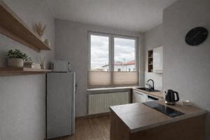 a small kitchen with a refrigerator and a window at Apartament SLEEP&GO Ostrowiec Świętokrzyski in Ostrowiec Świętokrzyski