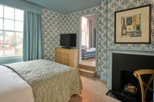a bedroom with a bed and a fireplace at Hotel du Vin Henley in Henley on Thames